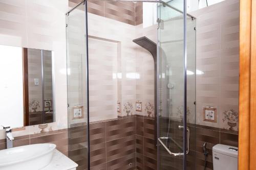 头顿Sao Mai Hotel & Apartment的一间带卫生间的浴室内的玻璃淋浴间