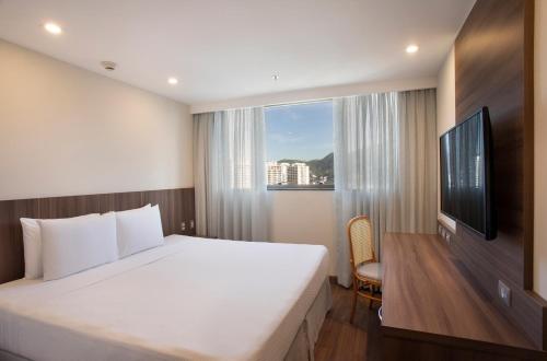 里约热内卢Windsor Tower Hotel的一间卧室设有一张大床和一个窗户。