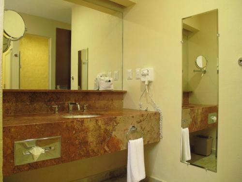 图斯特拉古铁雷斯Palmareca Inn-Suites-Studio的一间带水槽和镜子的浴室