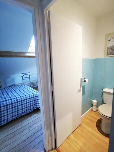 ArchesLe Clos de la Borde, Chambre bleue的一间带卫生间的浴室和一张位于客房内的床。