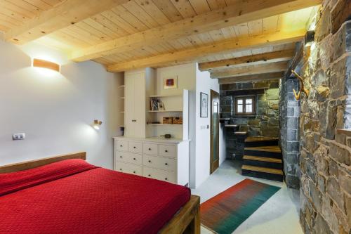 罗克Mountain Lodge Istria, Tiny house的一间卧室设有红色的床和石墙