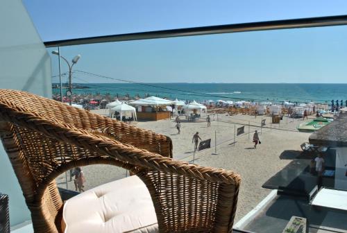 艾福雷诺德Vila Ryanna Beach pe plaja Belona的俯瞰海滩的阳台上的藤椅