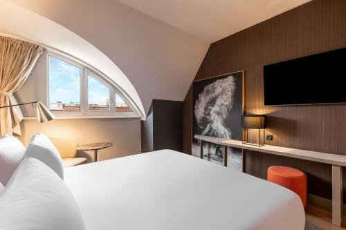 萨尔茨堡NH Collection Salzburg City的配有一张床和一台平面电视的酒店客房