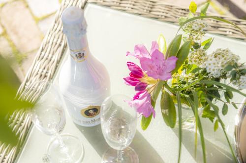 圣彼得奥尔丁Ferienhaus Koellers Hus的桌子上放着一瓶葡萄酒、酒杯和鲜花