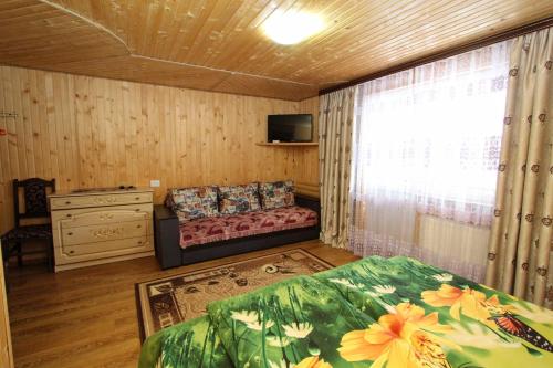 亚布卢尼齐亚Гостинний комплекс "У Валентини"的一间卧室配有一张床,窗户配有沙发