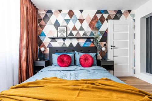 卡托维兹Apartament Frida Katowice Ligota的一间卧室配有一张大床和两个红色枕头