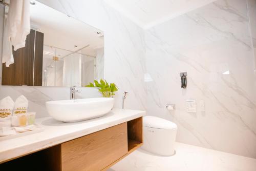 河静Songlam Waterfront Hotel的白色的浴室设有水槽和卫生间。
