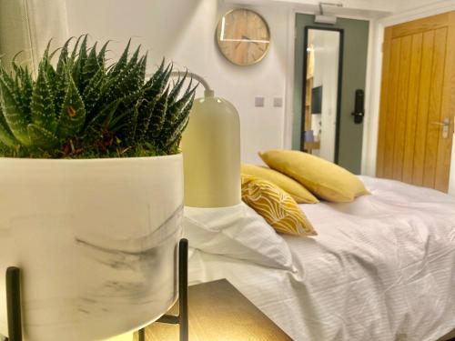 温彻斯特Station Rooms的一间卧室,配有一张带花瓶的床铺,种植了植物
