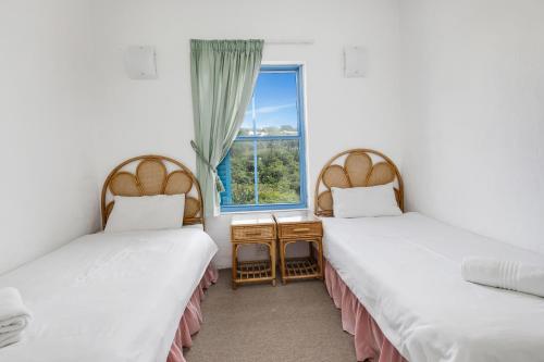 巴利托Santorini Kallisti 8的带窗户的客房内的两张床