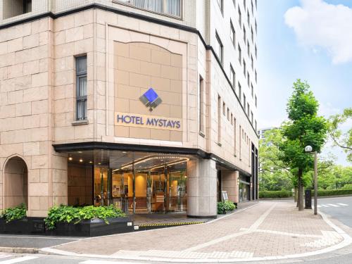 广岛HOTEL MYSTAYS Hiroshima Peace Park的上面有酒店设备不合的标志的建筑