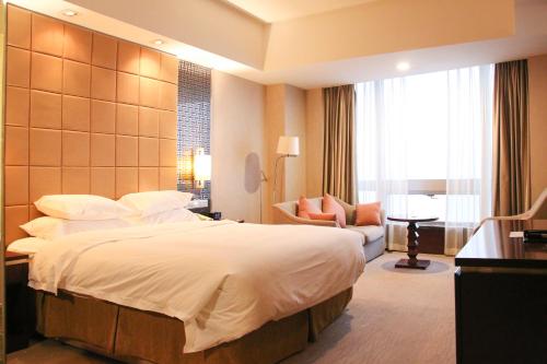 烟台烟台南山皇冠假日酒店的酒店客房设有一张大床和一张沙发。