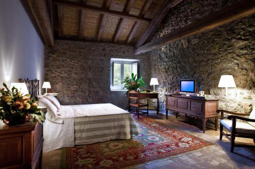圣格雷戈廖迪卡塔尼亚拉卡鲁巴杂酒店的一间卧室配有一张床、一张书桌和一台电视
