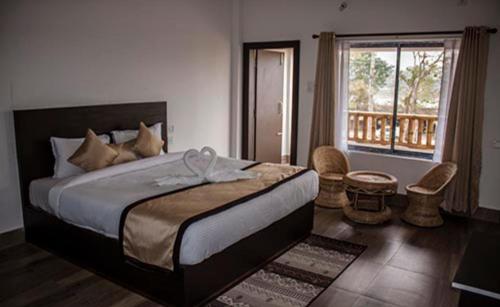 卡齐兰加Shivaji Inn Kaziranga的一间带大床的卧室和一个阳台