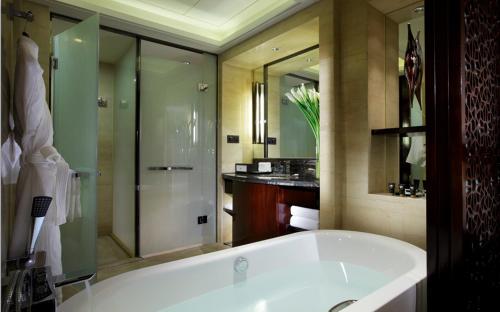 成都成都保利公园皇冠假日酒店的大型浴室设有浴缸和淋浴。