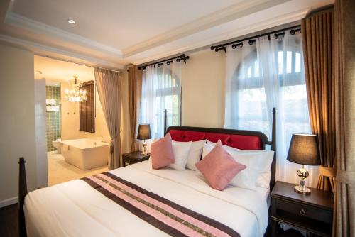 清迈Nanta Glam CM Hotel & Residences的一间带大床的卧室和一间浴室