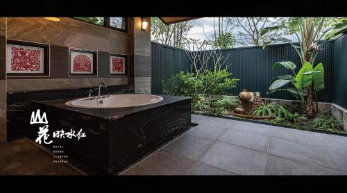 Yuemei山花映水紅莊園民宿的一间带大浴缸和花园的浴室