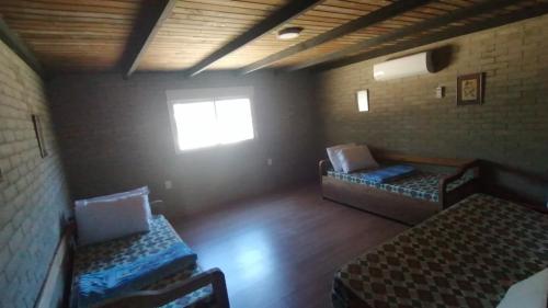 若雷吉贝里Casa en Jaureguiberry a 5 cuadras de la playa的一间空房间,设有两张床和窗户