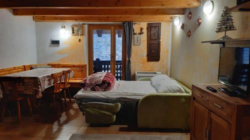 OllomontMaisonnette de montagne的一间带一张床的房间和一间带桌子的用餐室