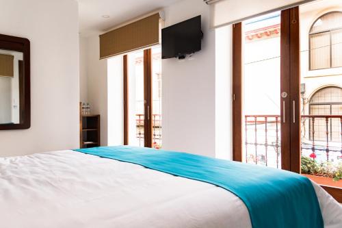 拉塔昆加REEC Latacunga by Oro Verde Hotels的卧室配有一张大床,墙上配有电视
