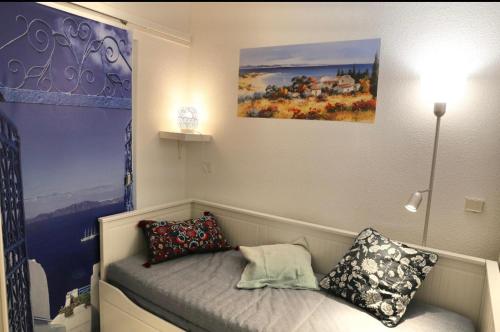 博索莱伊Azzurra的客房配有带枕头的床和绘画作品