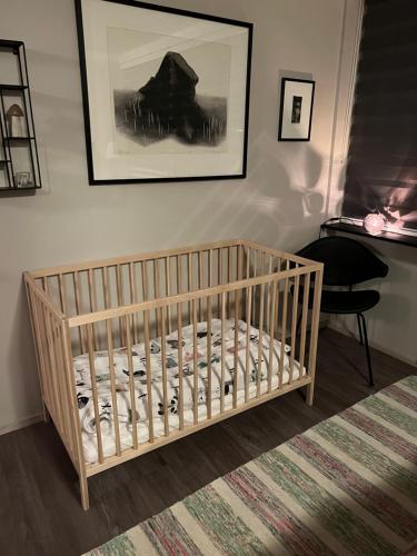 雷克雅未克Cosy Harbour Apartment的墙上有照片的房间的婴儿床