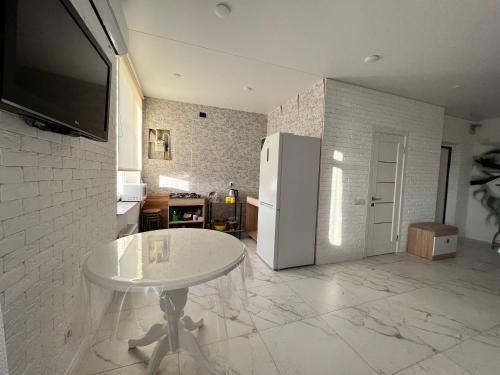 尤日内New Marine Apartment的厨房配有白色的桌子和冰箱。