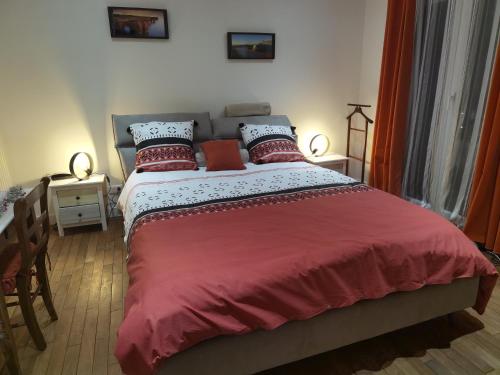 马恩河畔莱佩尔勒LES PINGOUINS DE LA MARNE的卧室配有一张大床,提供红色床单和枕头