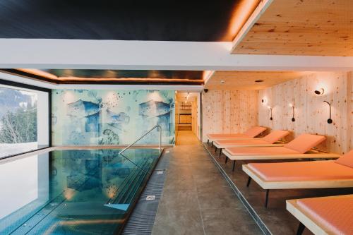 沃瑟姆阿尔伯格Alpin - Studios & Suites的一个带游泳池和一些长凳的房间