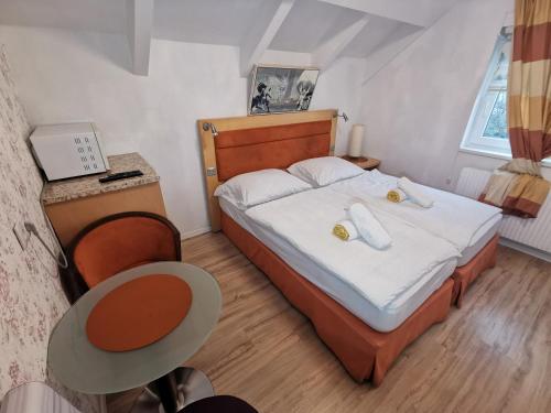 维也纳附近格拉斯多夫Pension Föhrenhain的一间小卧室,配有一张床和一张桌子