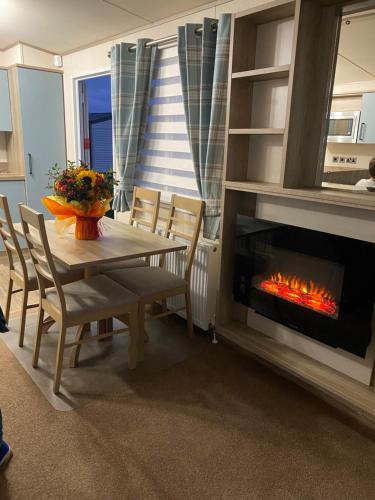 Littlestone-on-Seaholidayhome-romneysands holiday park的一间带桌子和壁炉的用餐室