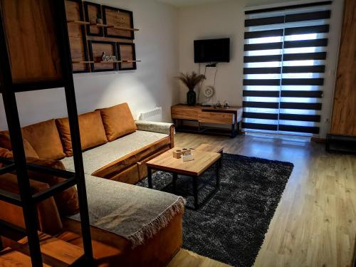新瓦罗什Apartman Mali Raj Zlatar的带沙发和咖啡桌的客厅