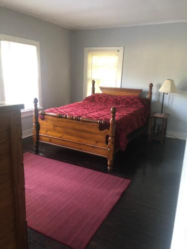 ClemmonsPrivate Cottage in Rural Setting的一间卧室配有一张带红色床罩的木床