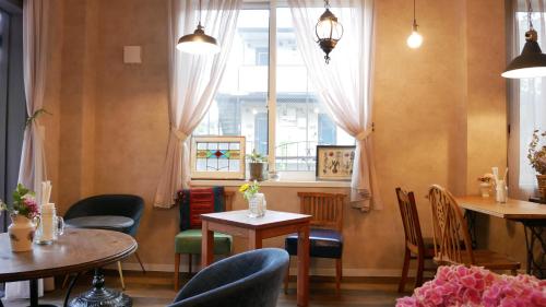 东京7 Rooms Hotel & Cafe的餐厅设有桌椅和窗户。