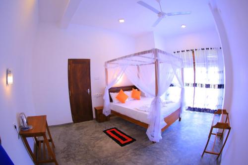 迪克韦勒Abinu"s Place的一间卧室配有带橙色枕头的天蓬床