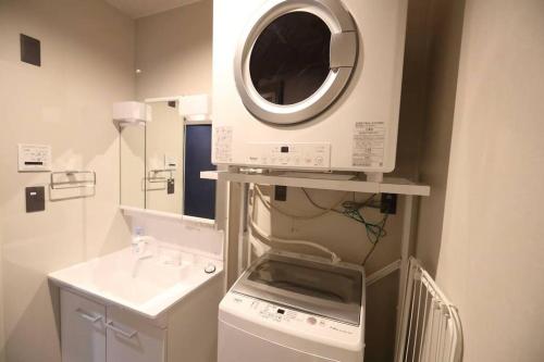 福冈White Crystal RoomB的厨房配有洗衣机和微波炉。