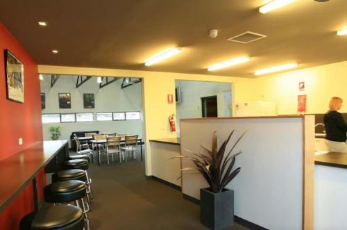 斯旺西Swansea Backpackers的餐厅设有酒吧、凳子和桌子