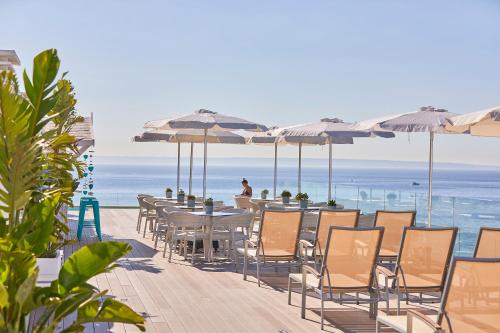 帕尔马诺瓦伯恩马尔公寓酒店的海滩上的桌椅和遮阳伞