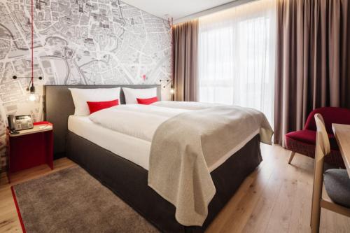 多特蒙德IntercityHotel Dortmund的酒店客房配有一张带红色枕头的大床