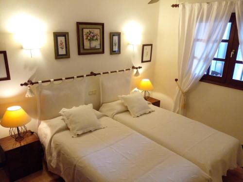 卡门港Chalet Nº 7 Tajinaste的一间卧室设有两张床、两盏灯和一个窗户。