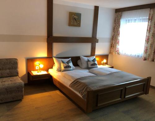 比希尔巴赫Landhaus Bichlbach的卧室配有床、椅子和窗户。