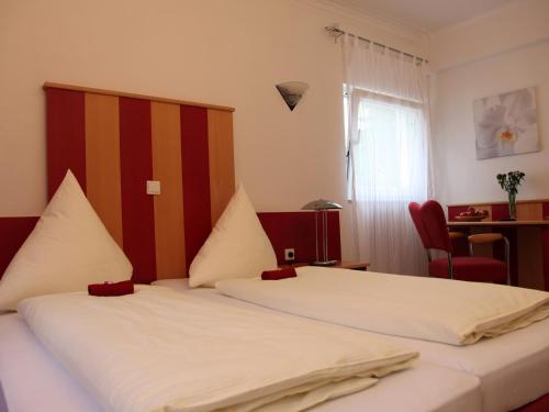 杜塞尔多夫卡萨别墅酒店的一间卧室设有两张床、一张桌子和一个窗口。