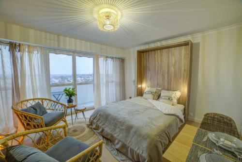 布尔日Bel aparté, cosy, vue panoramique cathédrale的一间卧室设有一张床和一个大窗户