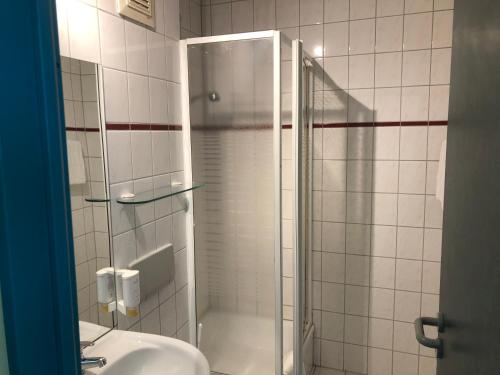 施科伊迪茨REGIOHOTEL Halle Leipzig Airport的带淋浴和盥洗盆的浴室