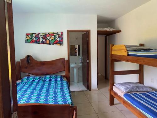 伊列乌斯Casa Amarela na praia para 13 pessoas的带两张双层床和一间浴室的客房