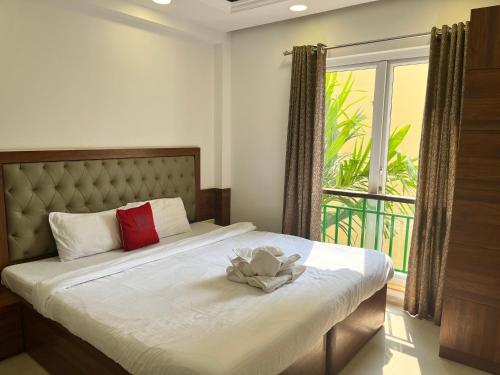 巴加Areia De Goa, Comfort Stay Apartment near Baga Beach的一间卧室,配有一张带鲜花的床