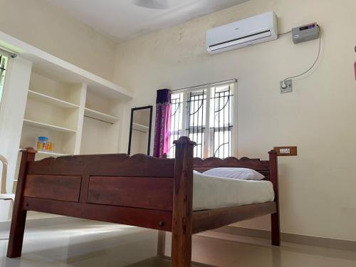 坦贾武尔Sarah Residency的卧室配有一张床,墙上配有空调