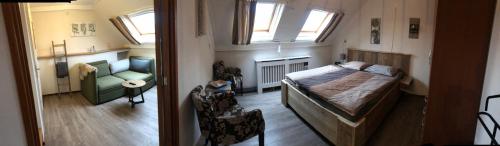 韦斯特卡佩勒Hotel Pieter de Coninck的一间卧室配有一张床、一张沙发和窗户。