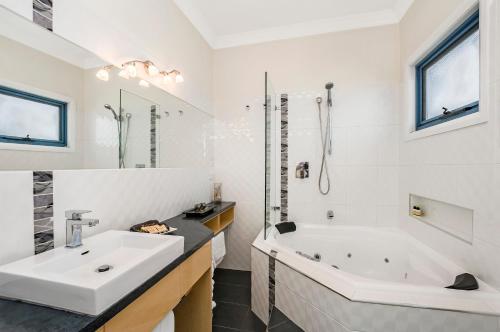 波特兰海景公寓的白色的浴室设有浴缸和水槽。