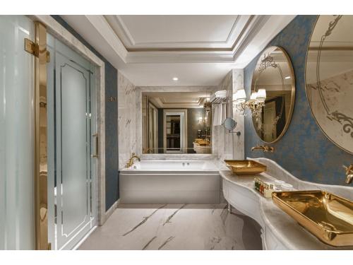沃科利达Kaya Artemis Resort & Casino的一间带浴缸和大镜子的浴室