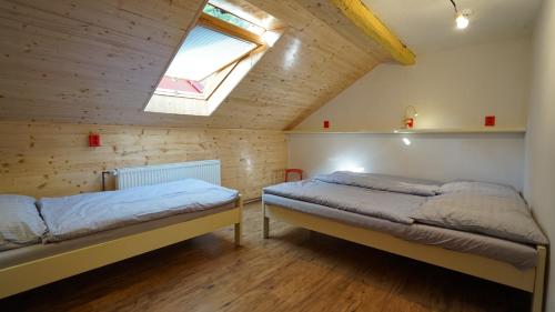 SloupChata pod hradem的一间卧室设有两张床和天窗